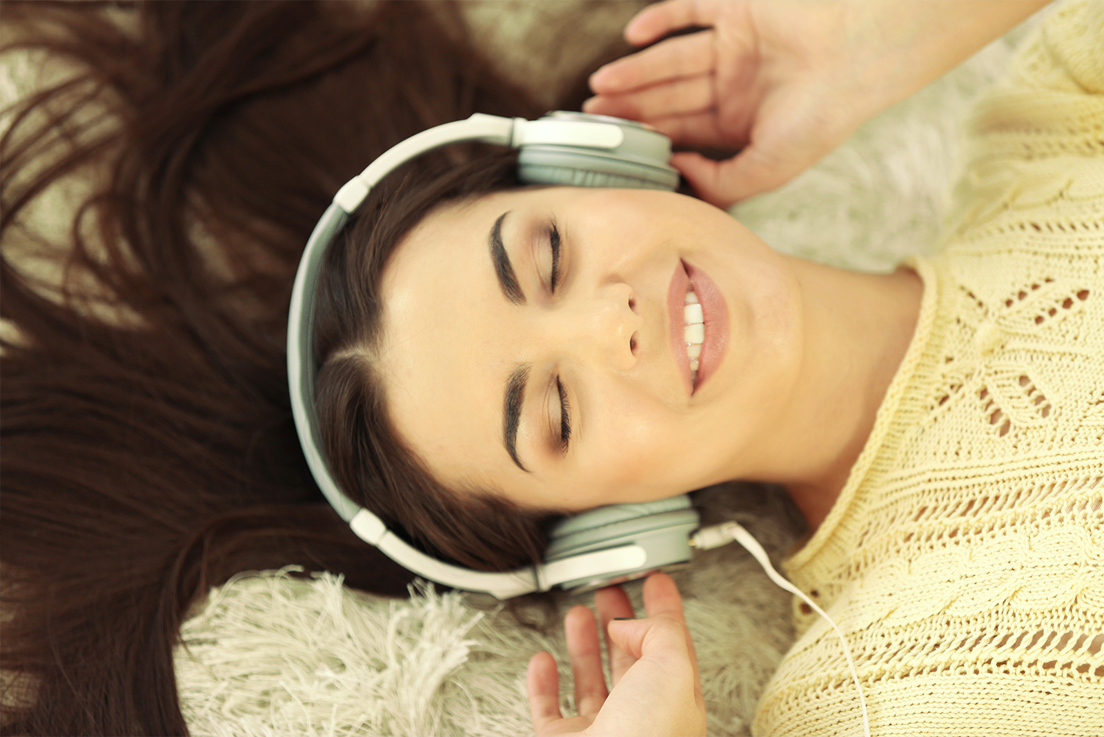 woman listening to synctuition with headphones lying down